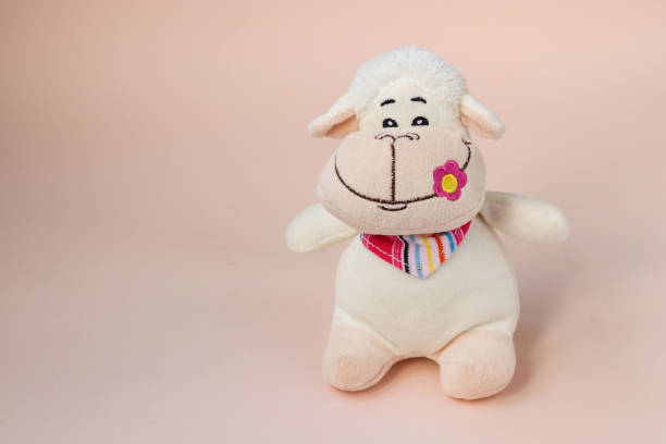 istock Soft funny toy sheep isolated on peach background 1303224489
