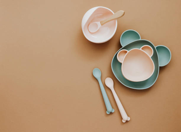 istock Top view neutral baby cute tableware on brown background, flat lay , copy space 1303224804