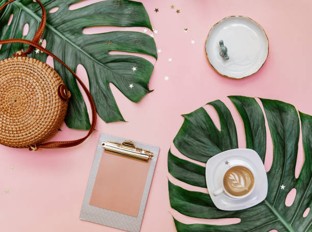 istock Feminine creative design workspace. Coffee, tropical leaves on pink background, blogger concept 1303224819