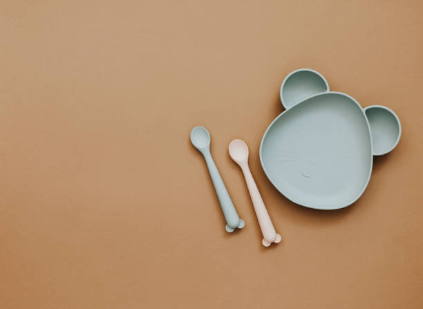 istock Top view neutral baby tableware on brown background, flat lay , copy space 1303224838