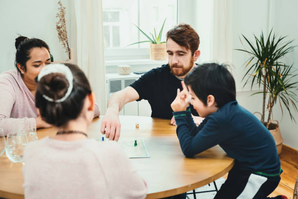 istock Mixed family playing with board game together at the table 1303224923