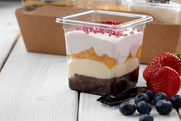 istock Creamy dessert in a plastic box on wooden table 1303225665