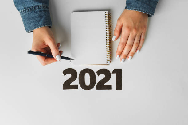 istock To do list. Top view of female hands writing in notebook 1303227952