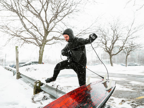 istock Young man getting ready to surf in winter 1303228772