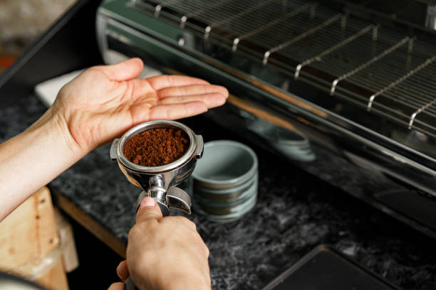 istock Woman coffee shop worker preparing coffee on professional coffee machine 1303229412