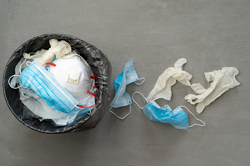 Used infectious masks and medical glove in the trash