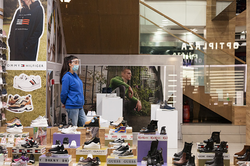 Picture of white caucasian women in belgrade, serbia, inside a shoe store in Belgrade, capital city of Serbia, while wearing a respiratory face mask and a face shield during the coronavirus health crisis.