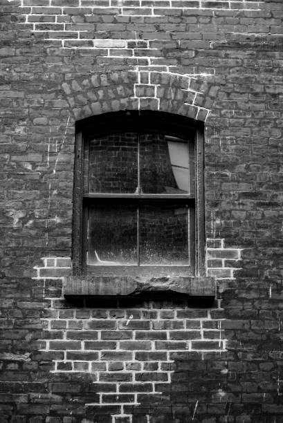 istock Old window pane in a red brick wall 1303235550