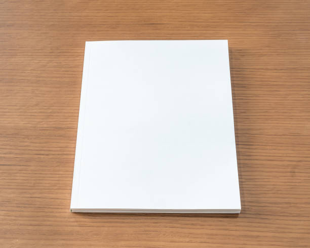 istock Book mockup with blank white front cover page a4 paperback mock up for catalog, magazine, menu, booklet, notebook, portfolio design template on wood table background 1303236843