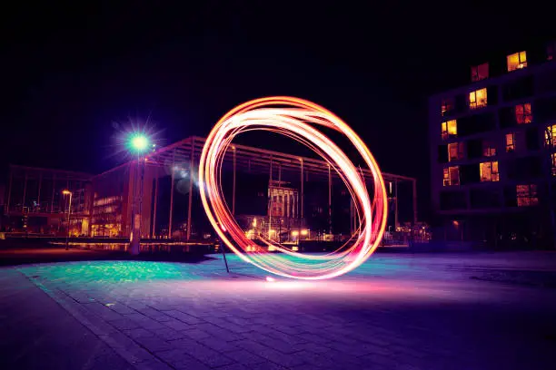 A bright red ring of clean energy in the middle of the city. It is night and the light is seen brightly