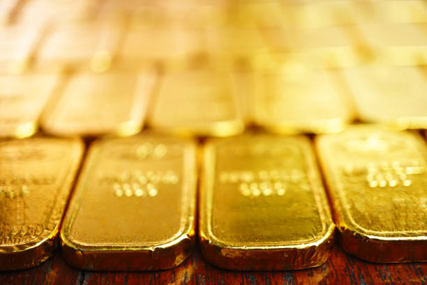 istock Selective focus on edge of gold bars which array on the table , investment concept . 1303237204