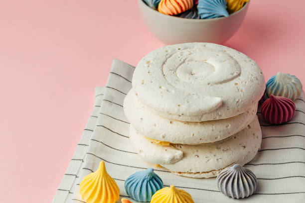istock White meringue cookie on pink background with colorful mini meringues 1303240456