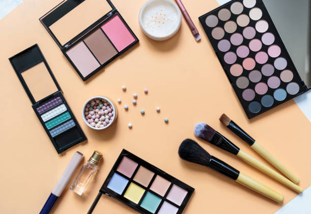 istock Makeup background. Eye shadow palette, powder, brushes, lipstick on yellow background. Flat lay, top view with copy space. Fashion, beauty, makeup, cosmetics. 1303242788