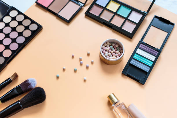 istock Makeup background. Eye shadow palette, powder, brushes, lipstick on yellow background. Flat lay, top view with copy space. Fashion, beauty, makeup, cosmetics. 1303243012