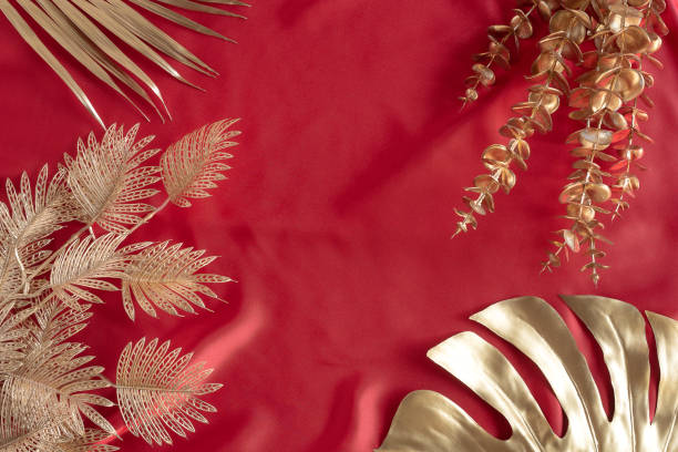 istock Gold leaves plant tropical monstera and palm pattern frame on a red background. 1303243019
