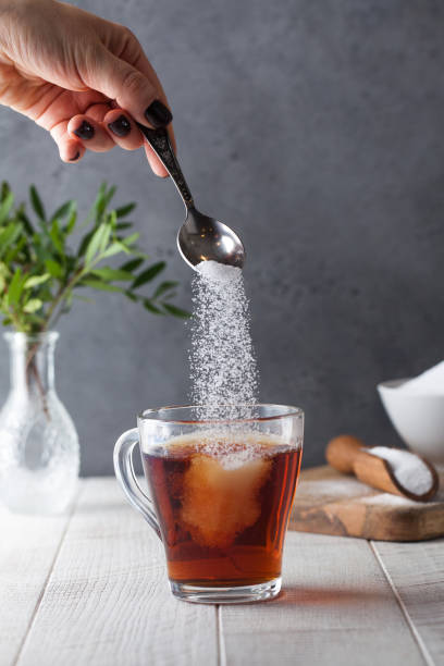 istock In a cup of tea, pour sugar from a teaspoon. 1303244287