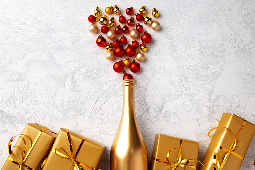 Flat lay composition with gold champagne bottle and Christmas balls top view