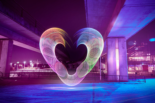Multicoloured heart painted with light effects in the middle of an urban area in a capital city