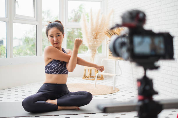 istock Asian woman trainer making online live streaming training and show how to exercise workout, yoga at home 1303246115