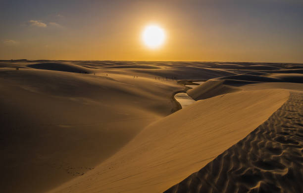 An immensity of white and fine sand dunes marks the paradisiacal path traveled by tourists in the midst of freshwater lagoons of turquoise and emerald blue, this is the Lencois Maranhenses National Park. Located in the Maranhao State in Brazilian northeastern the Lencois Maranhenses are considered the largest dunes field in South America / Central America, occupying an area of thoUnited Statesnd hectares. With a rare geological formation on the planet its dunes up to 40 meters high formed by the action of the winds arrive from the coast entering 25 km of the Brazilian coastline. Lençóis Maranhenses National Park stock pictures, royalty-free photos & images