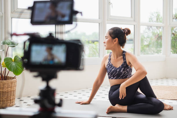 istock Asian woman trainer making online live streaming training and show how to exercise workout, yoga at home 1303246745