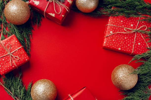 istock Red festive Christmas background with coniferous branches 1303247783
