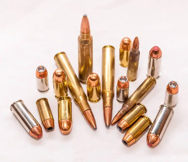 Different bullets for handguns and rifles in 40 caliber, 9mm and 223 caliber on a white background