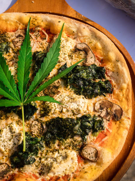 istock Cannabis pizza. Pizza mixed and decorate with fresh marijuana leaf. 1303249229