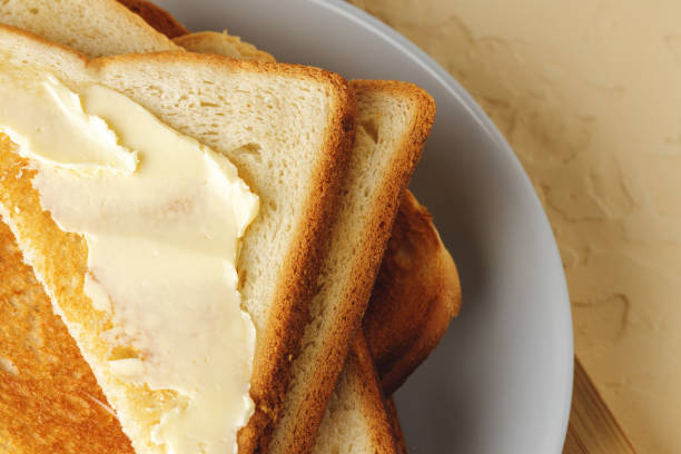 istock Simple breakfast. Toasted bread covered with butter 1303255338