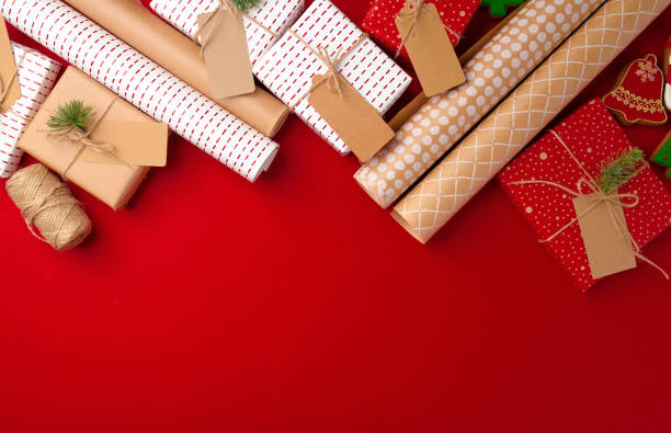 istock Christmas preparations concept with wrapping paper, gift boxes on red background 1303258170