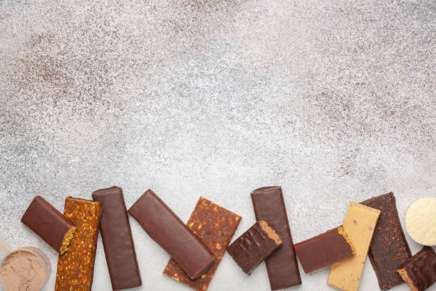 istock Whey protein powder in measuring scoop and different energy protein bar on grey background. Top view 1303258233
