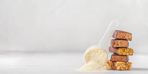 istock Whey protein powder in measuring scoop and different energy protein bar on grey background. 1303258240