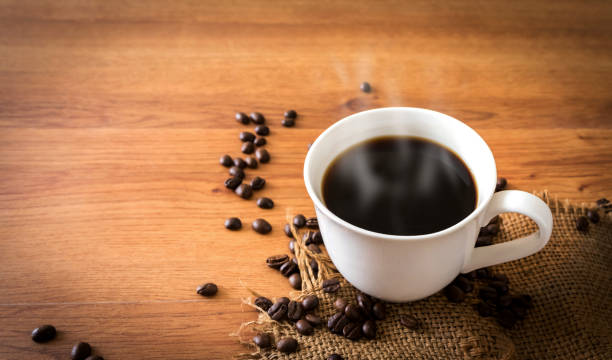 cup of coffee and coffee beans on old wooden background. stock photo