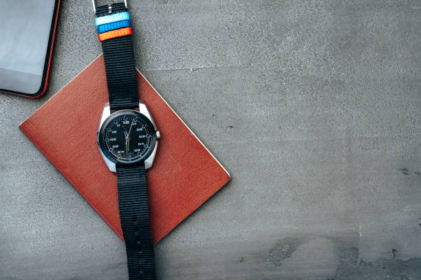 istock Male watch and notepad on dark grey table 1303258475