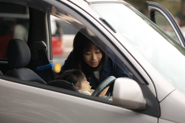 istock Mother putting a sleeping child on a child seat 1303273391