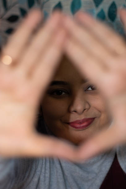 istock young girl smiling face from heart hand frame in different perspective 1303274392