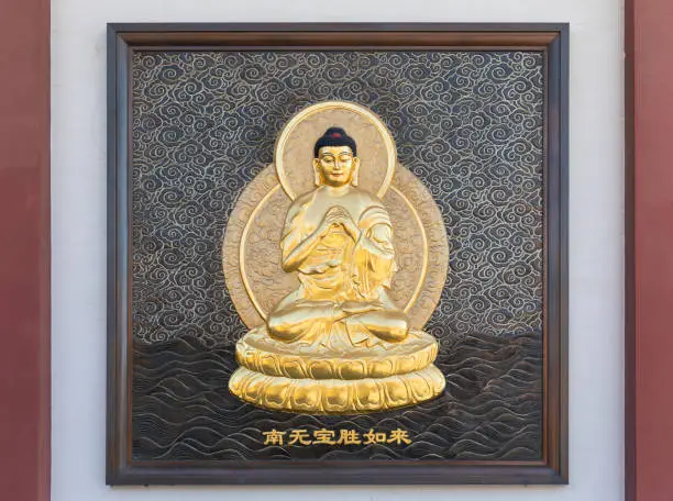 Photo of Golden relief of Namo Ratnaketu Tathagata, one of seven Tathagatas, on wall of octagonal pagoda in Qibao Temple