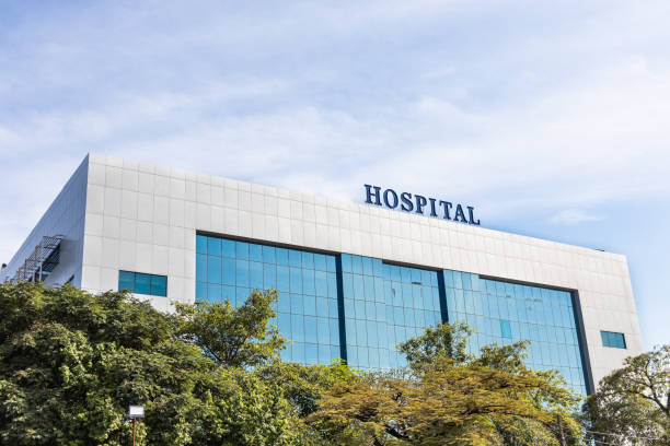 moderne gebäudefassade mit krankenhaus-wortbeschilderung - hospital stock-fotos und bilder