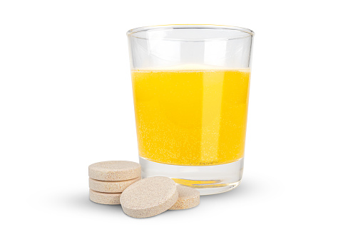 Orange flavored vitamin c effervescent tablet and dissolve in glass of water islated on white background with clipping paths.