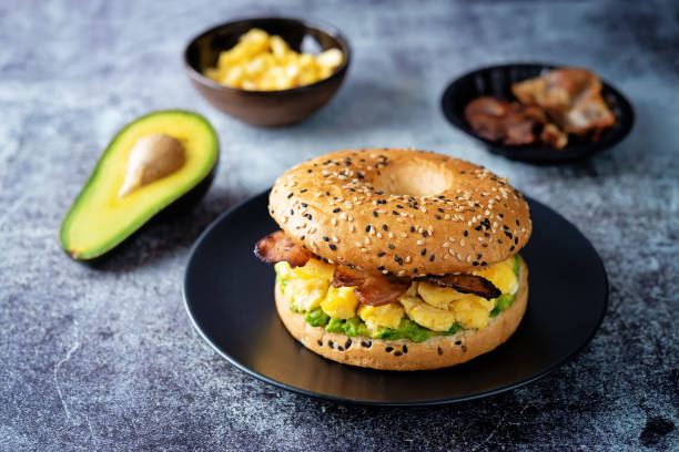 bagel di insalata di uova di avocado alla pancetta fritta - bun sandwich vegetable cream cheese foto e immagini stock