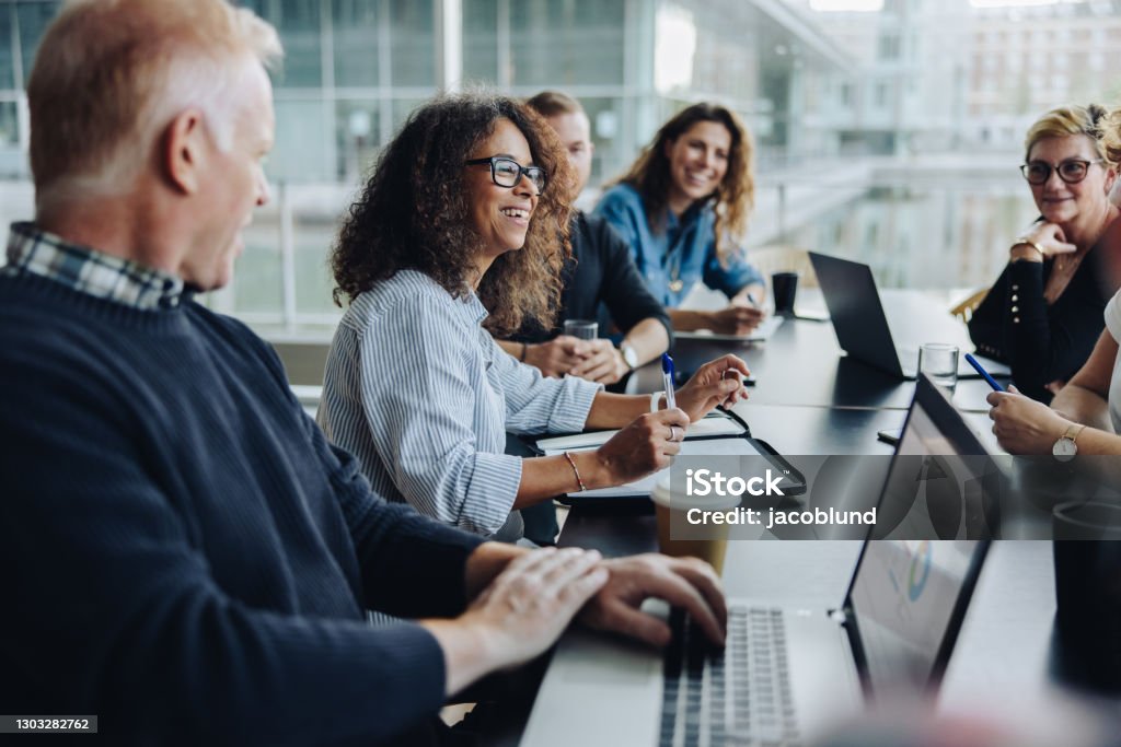 Multiracial business people having meeting Multi-ethnic business people smiling during a meeting in conference room. Team of professionals having meeting in boardroom. Meeting Stock Photo