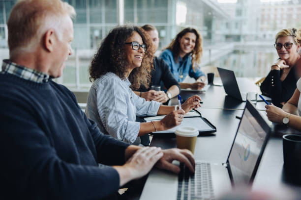 Multiracial business people having meeting Multi-ethnic business people smiling during a meeting in conference room. Team of professionals having meeting in boardroom. board room stock pictures, royalty-free photos & images