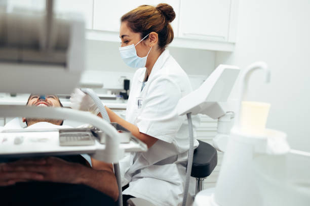 istock Dentist examining male patient's teeth in clinic 1303283816