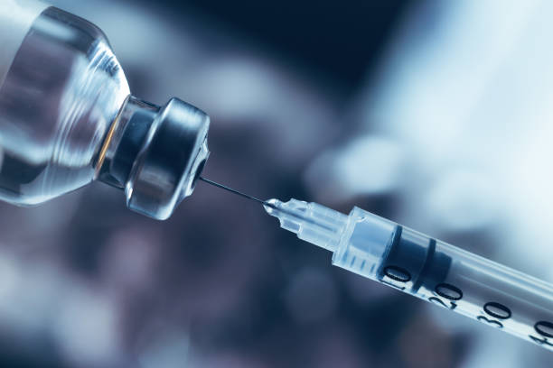 istock Syringe draws vaccine from ampoule. Coronavirus and flu cure. Close-up view 1303284586