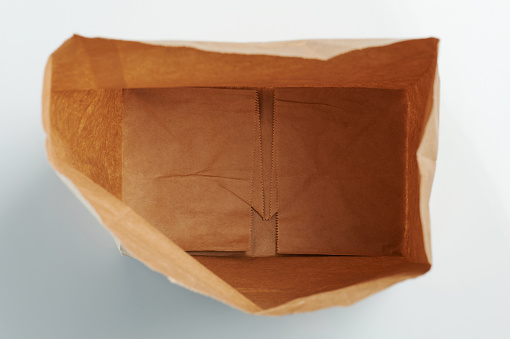 Open brown paper bag above top view isolated