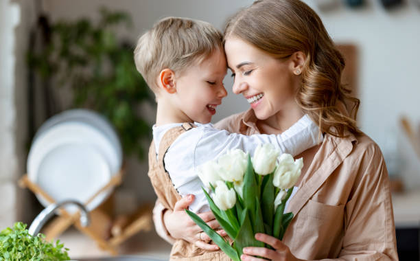istock Happy woman and boy with flowers touching forehead 1303290355