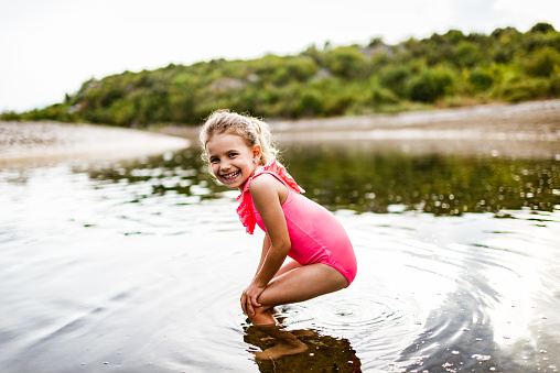 Beautiful girl having fun on a river during hot summer day.