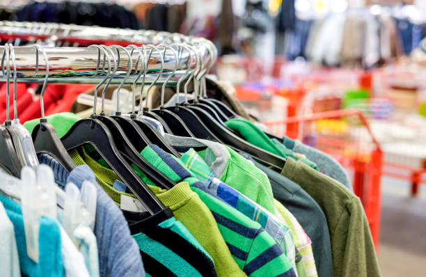 vue de plan rapproché d’une sélection de différents vêtements utilisés pour des hommes, des femmes et des enfants sur le support dans un magasin d’occasion ou un magasin d’épargne - dépôt vente photos et images de collection