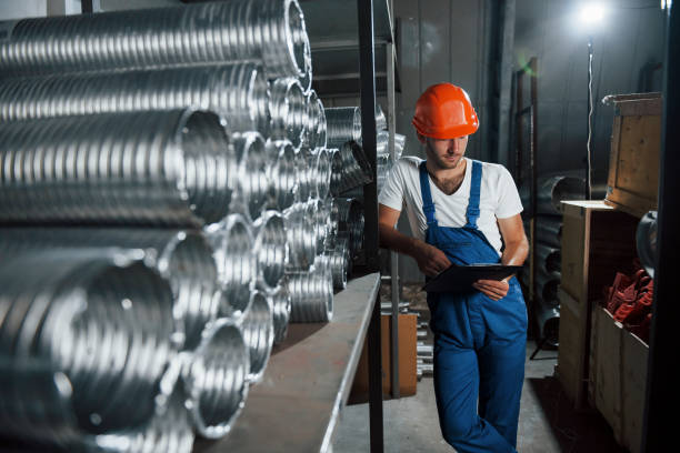 istock Alone in the storage. Man in uniform works on the production. Industrial modern technology 1303292976