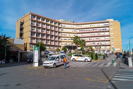 Seville, Andalusia, Spain; February 7th 2021: Main building of the Virgen del Rocio hospital in Seville (Andalusia, Spain). Emergency access with taxi rank.